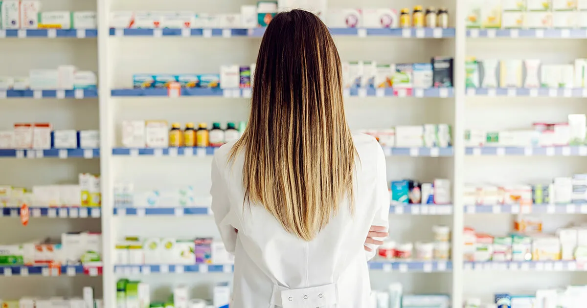 El interior de una Apotheke alemana con cajas de medicamentos y un farmacéutico en el mostrador