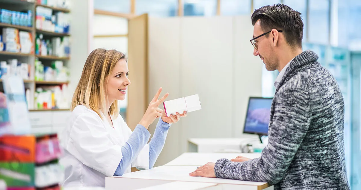 A person speaking to a German doctor, gesturing to explain where the pain is