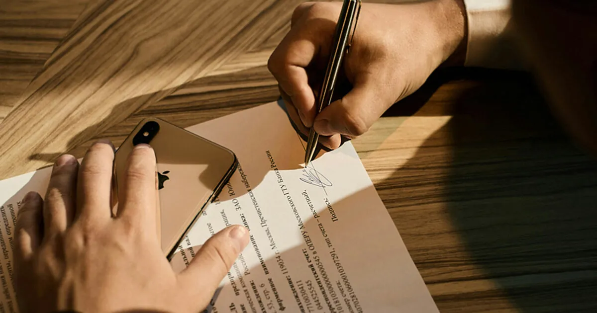 A German employment contract document with a pen resting on it, ready to sign