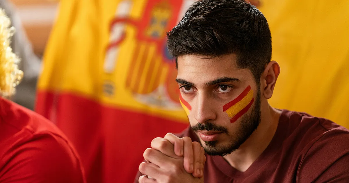 Kinder betreten am ersten Tag des Schuljahres ein spanisches Schulgebäude mit bunten Rucksäcken