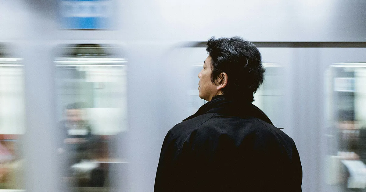 Uma pessoa no trem ou ônibus com fones de ouvido, olhando pela janela, calma e concentrada
