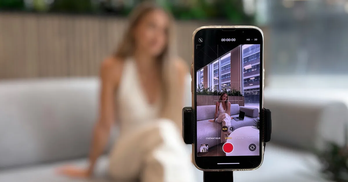 Uno schermo di telefono che mostra un video sull'apprendimento delle lingue, con quaderni e schede di vocabolario vicini