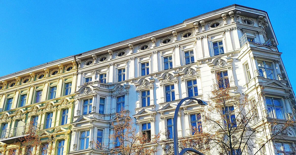 Ein Stapel deutscher Eigentumsdokumente auf einem Schreibtisch mit Stift und Wohnungsschlüsseln